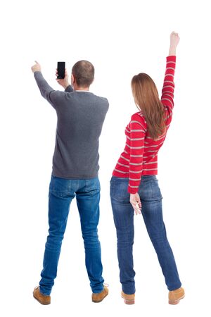 Back view of couple in sweater with mobile phone. beautiful friendly girl and guy together. Rear view people collection. backside view of person. Isolated over white background.の写真素材