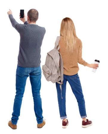 Back view of couple in sweater with mobile phone. beautiful friendly girl and guy together. Rear view people collection. backside view of person. Isolated over white background.の写真素材