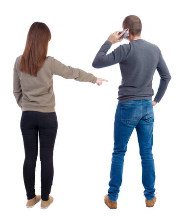 Back view of couple in sweater with mobile phone. beautiful friendly girl and guy together. Rear view people collection. backside view of person. Isolated over white background.の写真素材
