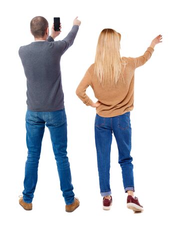 Back view of couple in sweater with mobile phone. beautiful friendly girl and guy together. Rear view people collection. backside view of person. Isolated over white background.の写真素材
