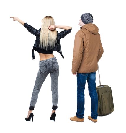 young couple in winter jacket traveling with suitcas. Back view. Rear view people collection. backside view of person. Isolated over white background.の写真素材