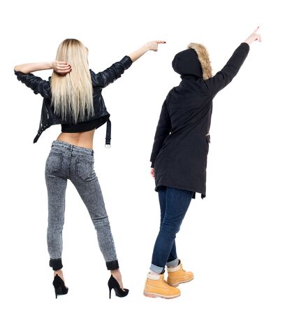 Back view of two pointing girl in winter jacket. Rear view people collection. backside view of person. beautiful woman friends showing gesture. Rear view. Isolated over white background.の写真素材