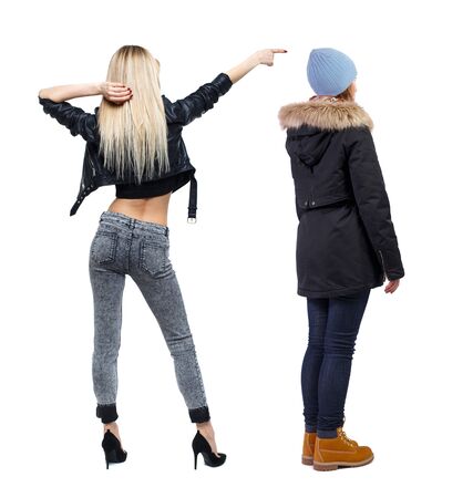 Back view of two pointing girl in winter jacket. Rear view people collection. backside view of person. beautiful woman friends showing gesture. Rear view. Isolated over white background.の写真素材