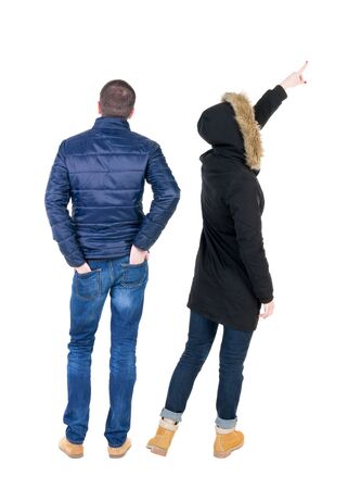 Back view of two pointing girl in winter jacket. Rear view people collection. backside view of person. beautiful woman friends showing gesture. Rear view. Isolated over white background.の写真素材