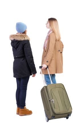 Back view of two woman in winter jacket traveling with suitcas. Back view. Rear view people collection. backside view of person. Isolated over white background.の写真素材