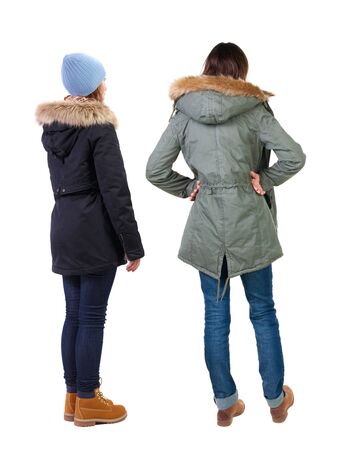 Back view of two young woman in winter jackets. Rear view people collection. backside view of person. Rear view. Isolated over white background. She clung to his girlfriendの写真素材