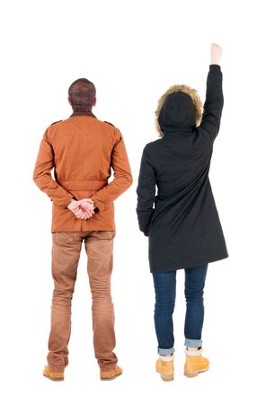 Back view of two pointing girl in winter jacket. Rear view people collection. backside view of person. beautiful woman friends showing gesture. Rear view. Isolated over white background.の写真素材