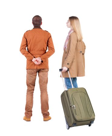 young couple in winter jacket traveling with suitcas. Back view. Rear view people collection. backside view of person. Isolated over white background.の写真素材