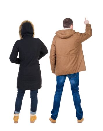 Back view of two pointing girl in winter jacket. Rear view people collection. backside view of person. beautiful woman friends showing gesture. Rear view. Isolated over white background.の写真素材