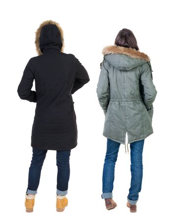 Back view of two young woman in winter jackets. Rear view people collection. backside view of person. Rear view. Isolated over white background. She clung to his girlfriendの写真素材