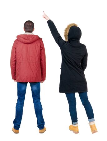 Back view of two pointing girl in winter jacket. Rear view people collection. backside view of person. beautiful woman friends showing gesture. Rear view. Isolated over white background.の写真素材