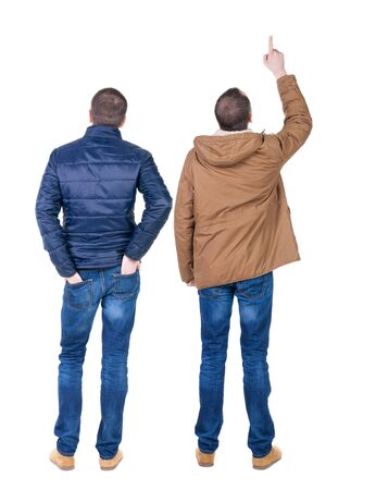 Back view of couple couple in winter jackets pointing. beautiful friendly girl and guy together. Rear view people collection. backside view of person. Isolated over white background.の写真素材