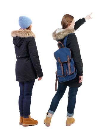 Back view of two pointing girl in winter jacket. Rear view people collection. backside view of person. beautiful woman friends showing gesture. Rear view. Isolated over white background.の写真素材