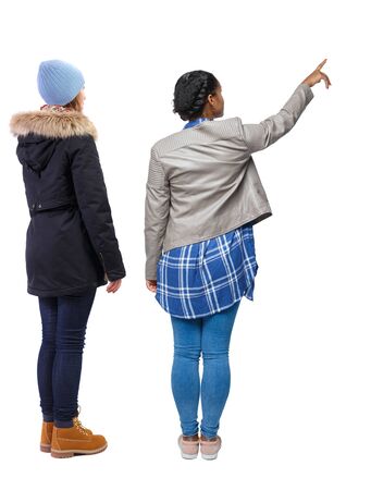 Back view of two pointing girl in winter jacket. Rear view people collection. backside view of person. beautiful woman friends showing gesture. Rear view. Isolated over white background.の写真素材