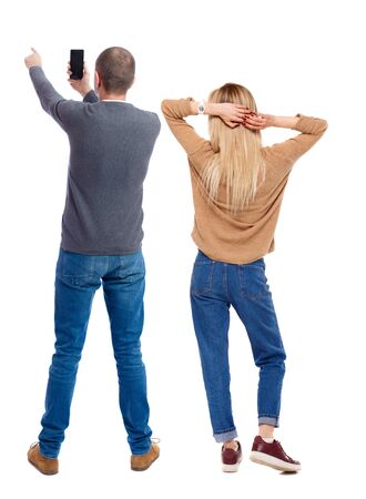 Back view of couple in sweater with mobile phone. beautiful friendly girl and guy together. Rear view people collection. backside view of person. Isolated over white background.の写真素材