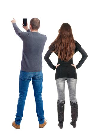 Back view of couple in sweater with mobile phone. beautiful friendly girl and guy together. Rear view people collection. backside view of person. Isolated over white background.の写真素材