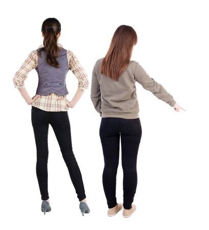 Back view of two pointing girl in sweater. Rear view people collection. backside view of person. beautiful woman showing gesture. Rear view. Isolated over white background.の写真素材