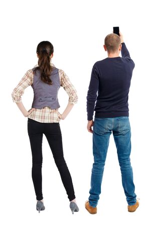Back view of couple in sweater with mobile phone. beautiful friendly girl and guy together. Rear view people collection. backside view of person. Isolated over white background.の写真素材
