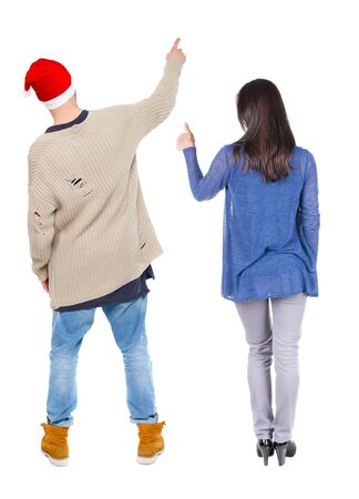 Back view of couple in sweater pointing. Rear view people collection. backside view of person. Isolated over white background.の写真素材