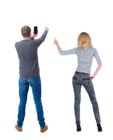 Back view of couple in sweater with mobile phone. beautiful friendly girl and guy together. Rear view people collection. backside view of person. Isolated over white background.の写真素材