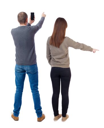 Back view of couple in sweater with mobile phone. beautiful friendly girl and guy together. Rear view people collection. backside view of person. Isolated over white background.の写真素材