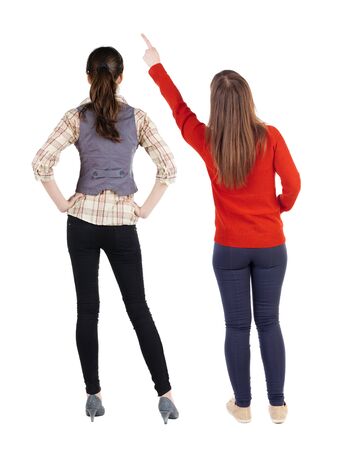 Back view of two pointing girl in sweater. Rear view people collection. backside view of person. beautiful woman showing gesture. Rear view. Isolated over white background.の写真素材