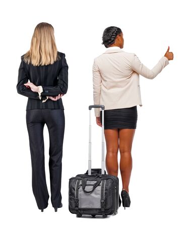 Back view of two business women in suit pointing. Business team. traveling with suitcas. Back view. Rear view people collection. backside view of person. Isolated over white background.の写真素材