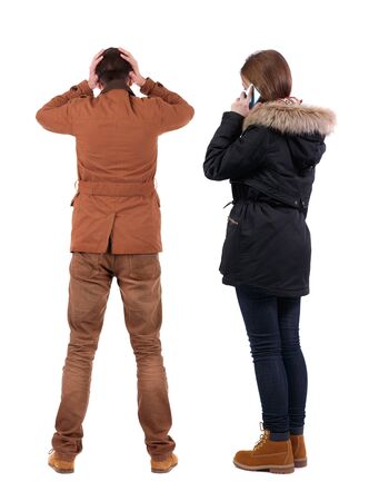 Back view of couple in winter jacket photographed on a mobile phone in winter jacket. beautiful friendly girl and guy together. Rear view people collection. backside view of person. Isolated over white background.の写真素材