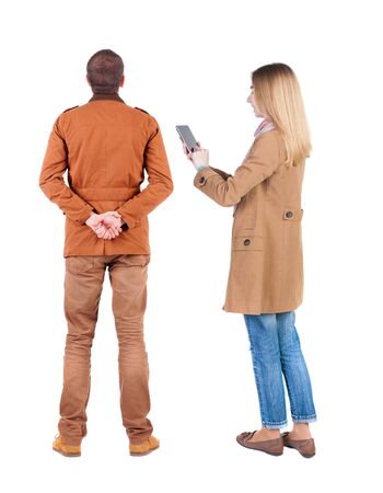 Back view of couple in winter jacket photographed on a mobile phone in winter jacket. beautiful friendly girl and guy together. Rear view people collection. backside view of person. Isolated over white background.の写真素材