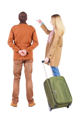 young couple in winter jacket traveling with suitcas. Back view. Rear view people collection. backside view of person. Isolated over white background.の写真素材