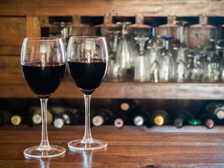 two glasses of red wine on a wooden tableの写真素材