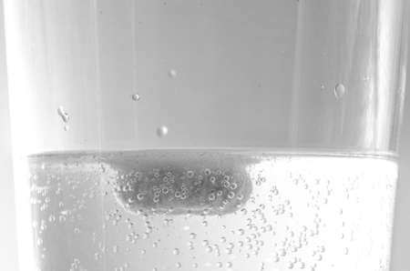 Effervescent tablet dissolving in a glass of waterの写真素材