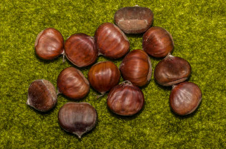 Closeup of some chestnuts over green grassの写真素材