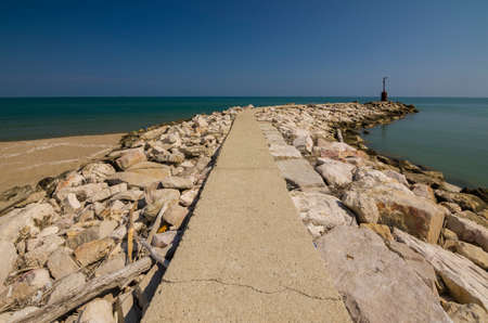 Walkway on the rocks leading to the old small abandoned lighthouseの写真素材