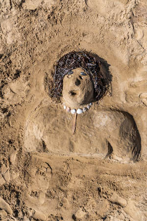 Sand man sculpture on the beach with decorationsの写真素材