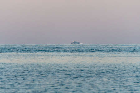 Seascape with rocks and ship in the distance