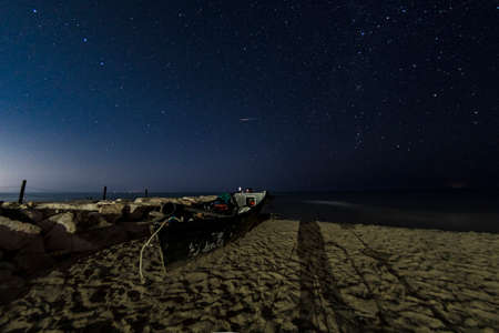 Beach and sea at night with starry skyの写真素材