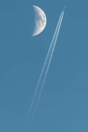 Plane passing near the moonの写真素材