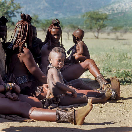May 15, 2005. Himba women do not identify and their children with traditional hairstyle, necklace and typical ocher skin. Epupa Falls, Kaokoland or Kunene Province, Namibia, Africaのeditorial素材