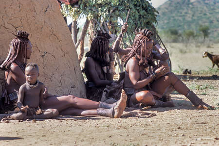 May 15, 2005.unidentified Himba women and their children with traditional hairstyle, necklace and typical ocher skin. Epupa Falls, Kaokoland or Kunene Province, Namibia, Africaのeditorial素材