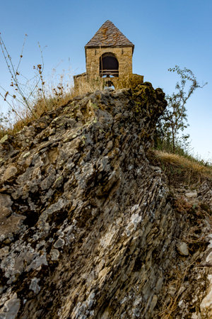 Old stone church tower on a cliff in the countryside