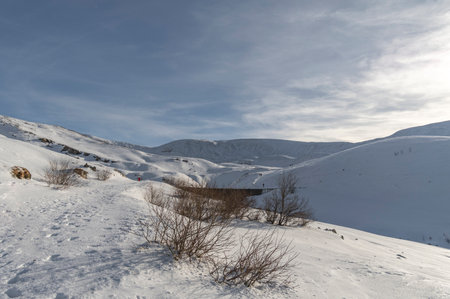 Winter landscape in the mountains. Snow-covered mountains and blue skyの写真素材