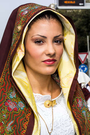 QUARTU SE, ITALY - SEPTEMBER 21, 2014: Parade of Sardinian costumes and carts for the grape festival in honor of the celebrations of Saint Helena, portrait of a beautiful woman wearing a traditional Sardinian costume - Sardiniaのeditorial素材