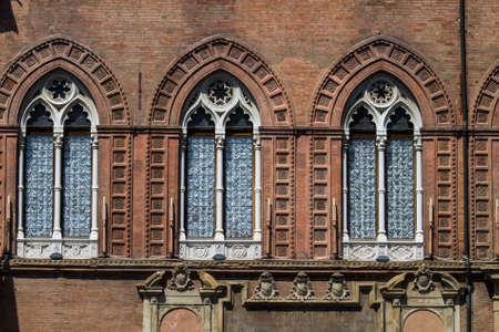 BOLOGNA, ITALY - JULY 22, 2017: Piazza Maggiore, detail of the windows of the Accursio or Comunale Palace which is the seat of the municipality - Emilia Romagnaのeditorial素材