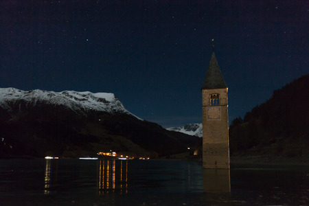 Resia/Reschen, South Tyrol, Italy, 2016 - 12 10: Curon Bell tower night sight appearing from lake surface, Resia, South Tyrol, Italyの写真素材