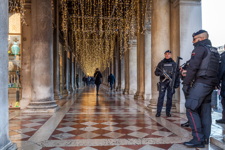 VENICE, ITALY - JANUARY 02 2018: Police on guard in  San Marco Square colonnade. This is a anti - terrorism service during Christmasのeditorial素材