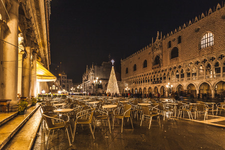 VENICE, ITALY - JANUARY 02 2018: night view of chairs and tables of a bar in Piazza San Marco with the Christmas tree in the backgroundのeditorial素材