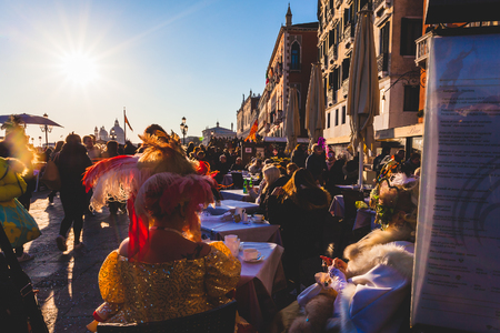 VENICE, ITALY - FEBRUARY 10 2018: Pair of colored carnival masks sitting on restaurant table near San Marco square in a sunny dayのeditorial素材