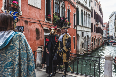 VENICE, ITALY - FEBRUARY 09 2018: Pair of carnival masks posing for photographers on a bridgeのeditorial素材