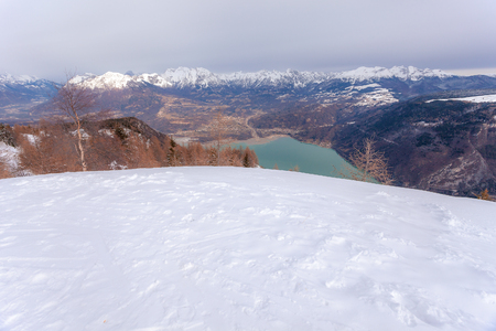 Winter panorama of green color Santa Croce lake on a cloudy day, Belluno, Italyの写真素材